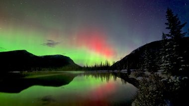 Northern lights behind mountains and lake Wallpaper